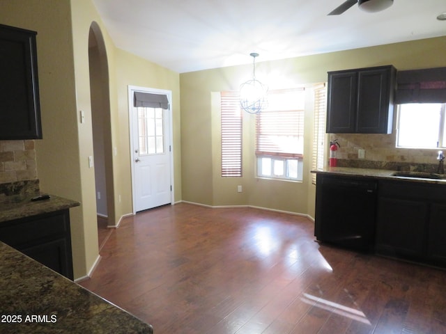 kitchen with decorative light fixtures, sink, black dishwasher, and a healthy amount of sunlight