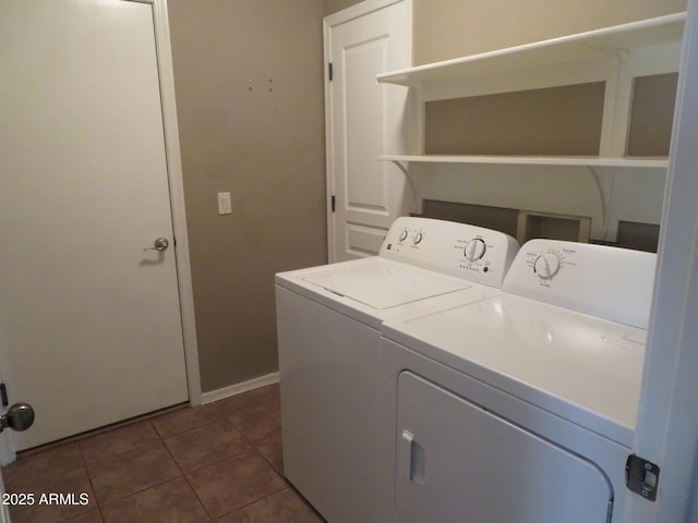 laundry area featuring dark tile patterned floors and washing machine and clothes dryer