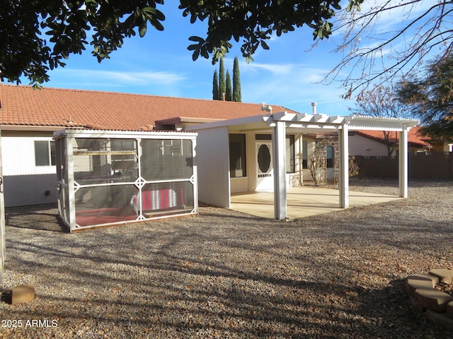 back of property with a patio, a pergola, and a sunroom