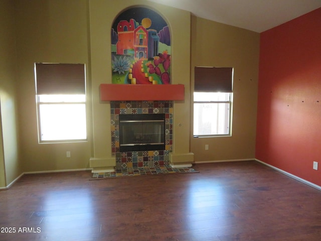 unfurnished living room with wood-type flooring, vaulted ceiling, and a fireplace