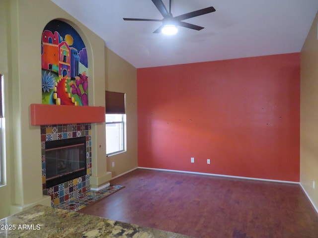 living room with ceiling fan, hardwood / wood-style floors, a fireplace, and lofted ceiling