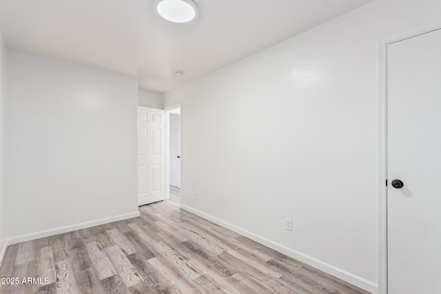 unfurnished room featuring wood finished floors and baseboards