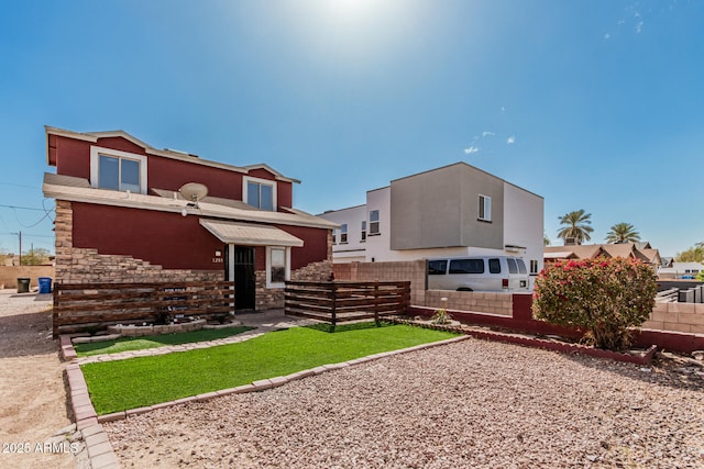 back of property featuring fence and stone siding