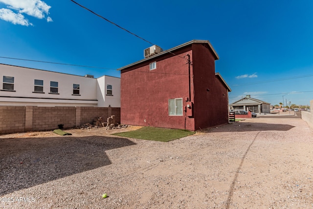 view of home's exterior with fence, central AC, and stucco siding