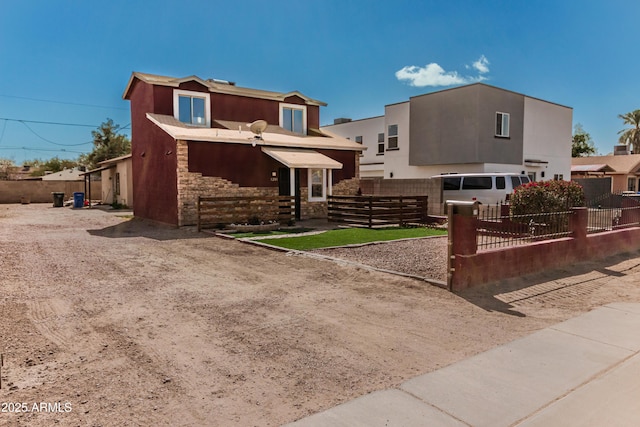 exterior space with a fenced front yard, stone siding, and stucco siding