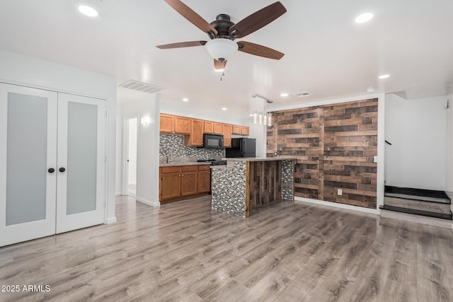 kitchen featuring black appliances, light wood-style floors, backsplash, and ceiling fan