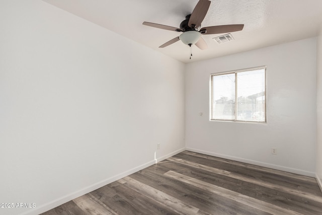 unfurnished room featuring a ceiling fan, dark wood-style floors, visible vents, and baseboards