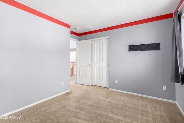 unfurnished bedroom with light carpet and a closet