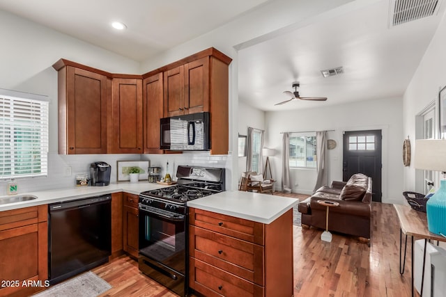 kitchen with visible vents, backsplash, black appliances, and open floor plan