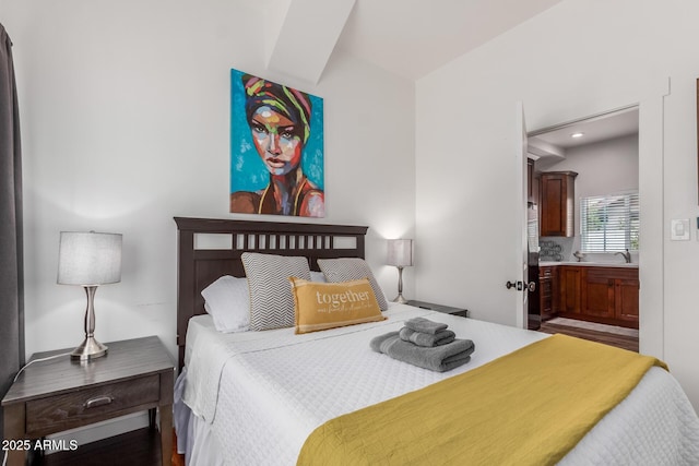 bedroom with recessed lighting, connected bathroom, and wood finished floors