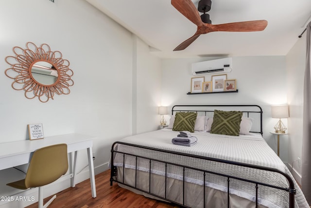 bedroom featuring an AC wall unit, a ceiling fan, baseboards, and wood finished floors