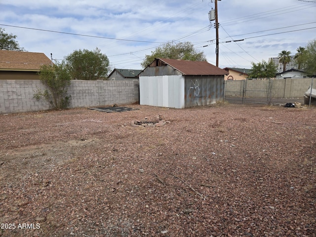 view of yard with an outdoor structure, a storage shed, and a fenced backyard