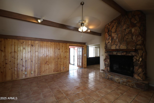 36655 N 25th St, Cave Creek, AZ 85331 - unfurnished living room featuring a ceiling fan, a stone fireplace, tile patterned floors, vaulted ceiling with beams, and wood walls