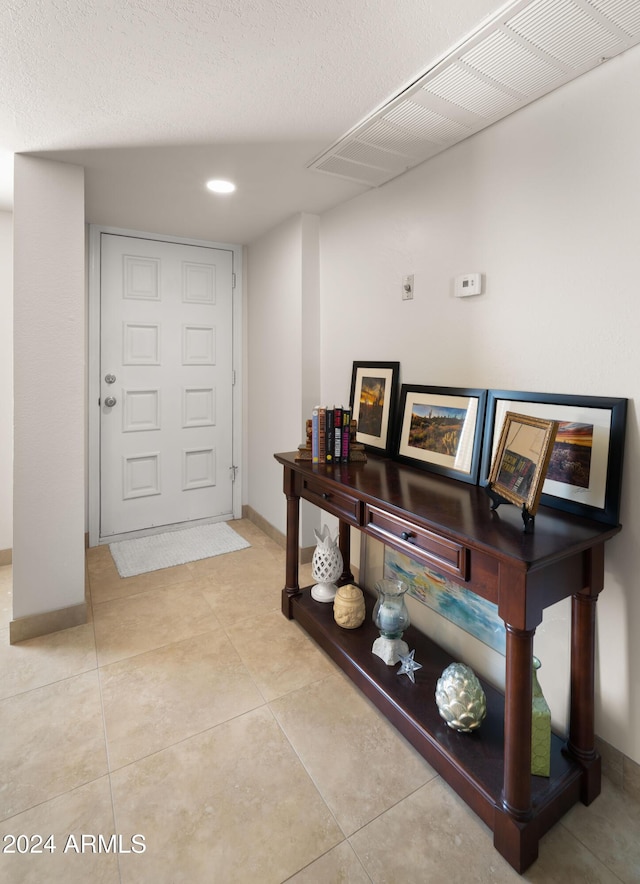 interior space with light tile patterned floors and a textured ceiling