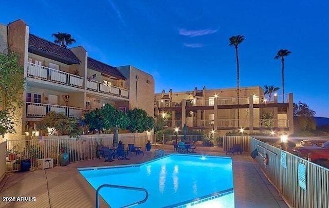 pool at dusk featuring a patio area