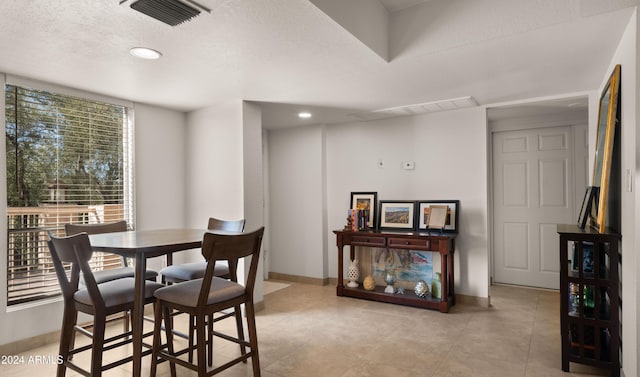 tiled dining room with a textured ceiling