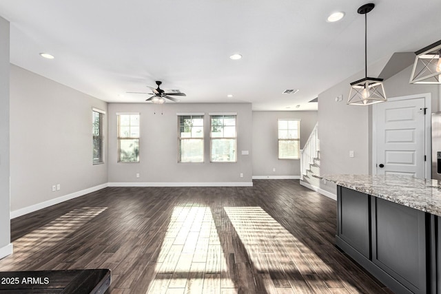 unfurnished living room with dark hardwood / wood-style flooring and ceiling fan