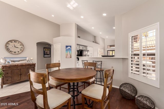 tiled dining space with a high ceiling