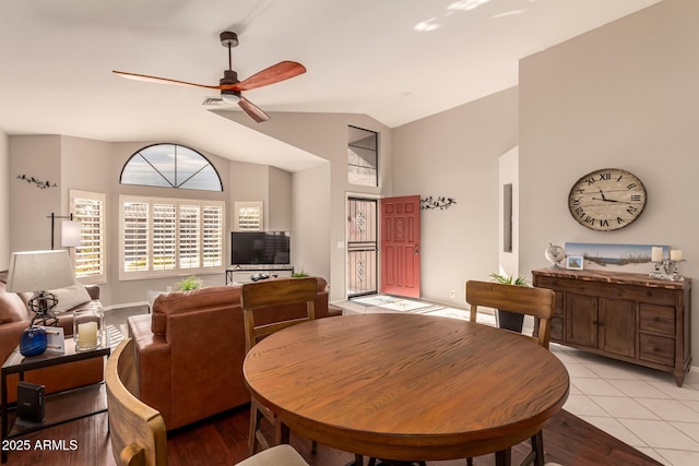 tiled dining area featuring lofted ceiling and ceiling fan