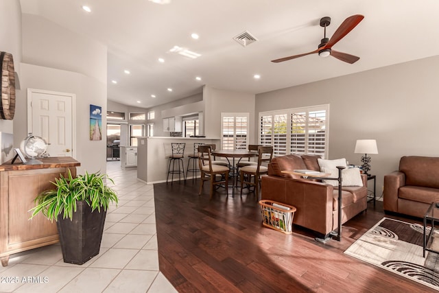 living room with vaulted ceiling, light tile patterned floors, and ceiling fan