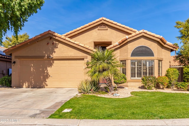 mediterranean / spanish-style house featuring a garage and a front lawn