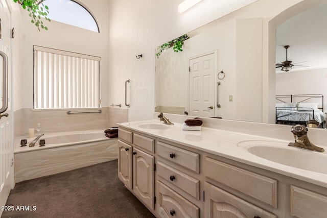 bathroom with vanity, a washtub, and ceiling fan