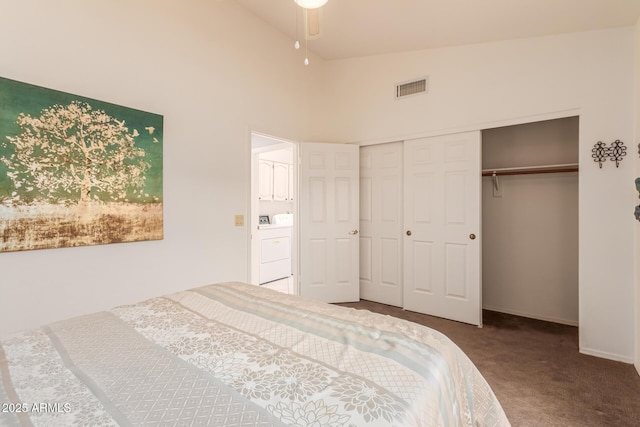 carpeted bedroom featuring washer / clothes dryer, high vaulted ceiling, and a closet