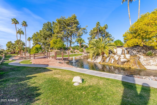 surrounding community featuring a water view and a lawn