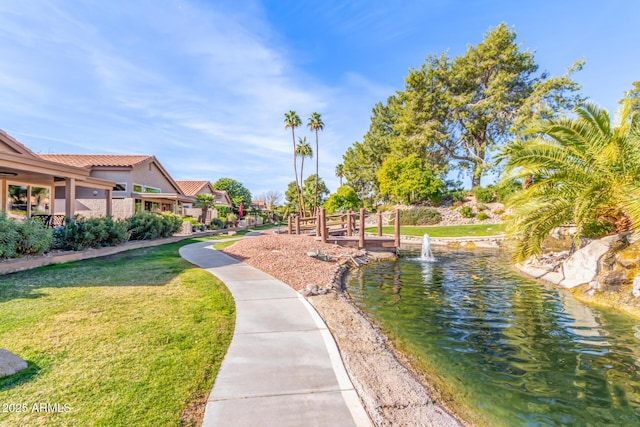 surrounding community with a lawn and a water view