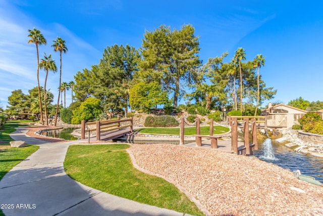 view of home's community with a water view and a yard