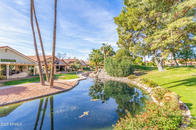 view of home's community featuring a water view and a yard