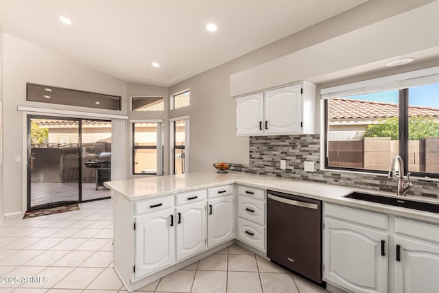 kitchen featuring dishwasher, lofted ceiling, white cabinets, and kitchen peninsula