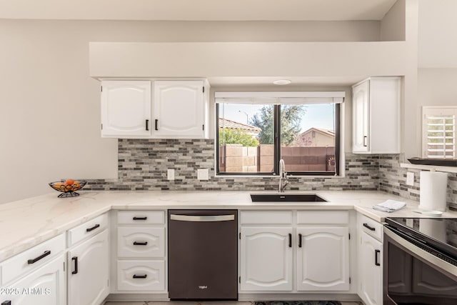 kitchen featuring white cabinetry, sink, dishwashing machine, backsplash, and light stone counters