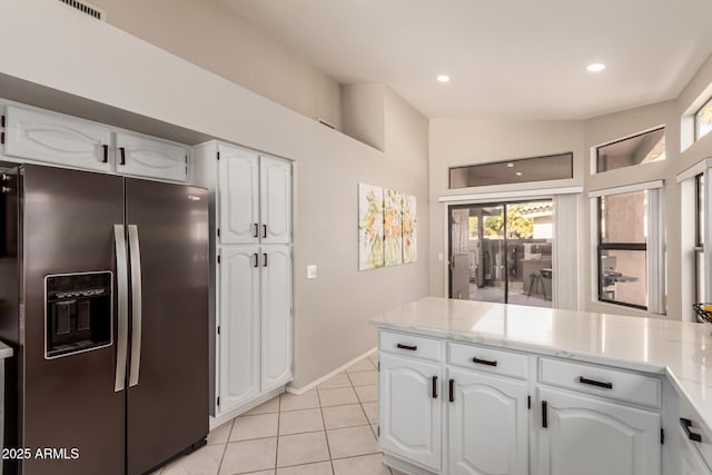 kitchen featuring light tile patterned floors, white cabinets, and stainless steel fridge with ice dispenser