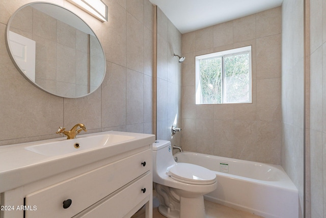 full bathroom with vanity, tiled shower / bath combo, tile walls, and toilet