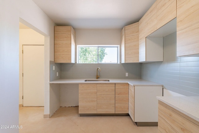 kitchen featuring backsplash, light brown cabinetry, and sink