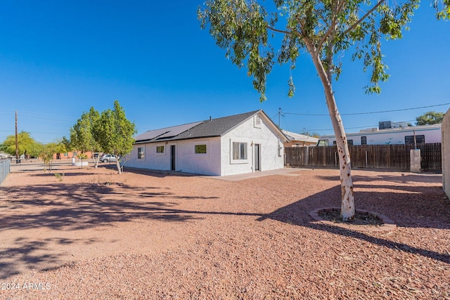 back of property featuring solar panels