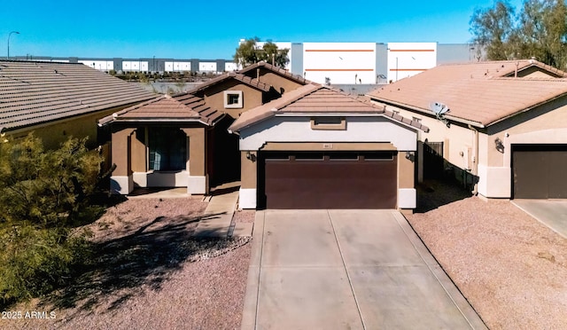 view of front of house featuring driveway, a tile roof, a garage, and stucco siding