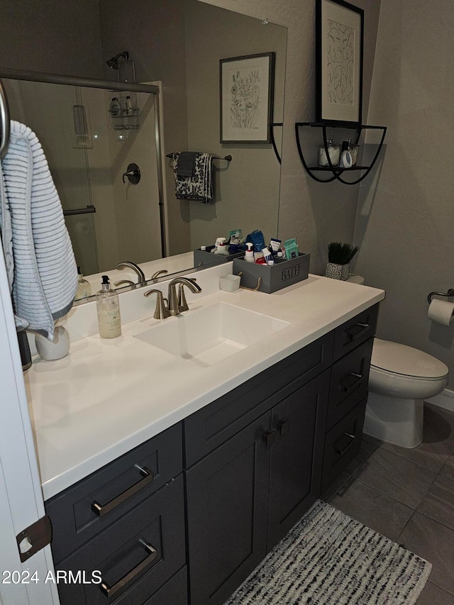 bathroom featuring tile patterned floors, vanity, toilet, and an enclosed shower