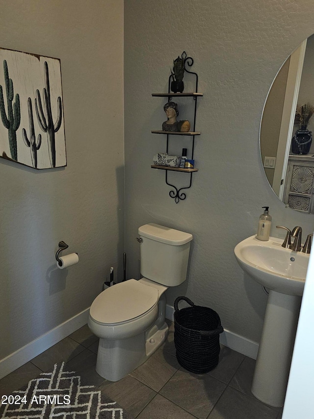 bathroom featuring tile patterned flooring, toilet, and sink