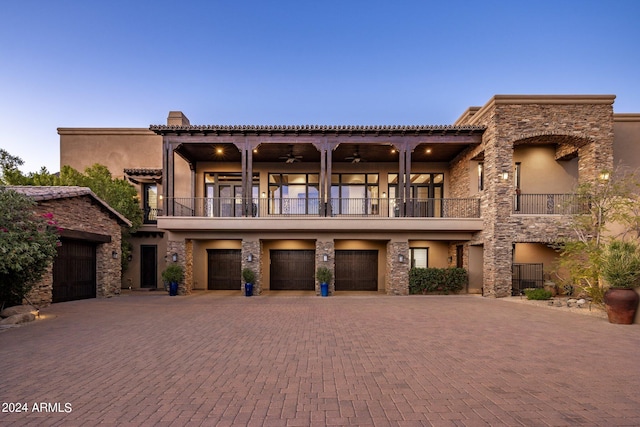 view of front of home with a balcony, ceiling fan, and a garage