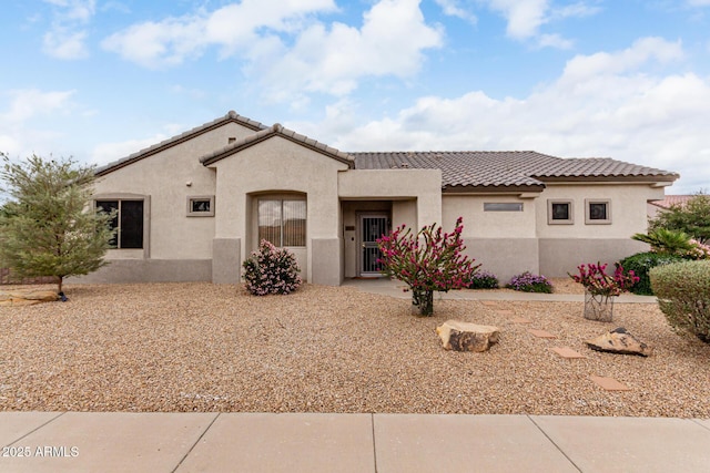 mediterranean / spanish house featuring a tiled roof and stucco siding