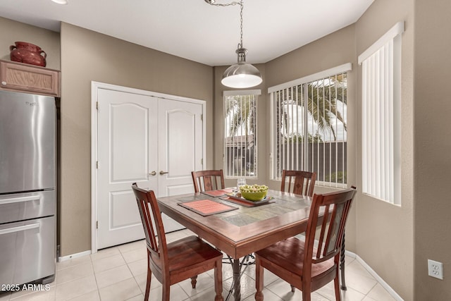 dining area featuring light tile patterned floors and baseboards