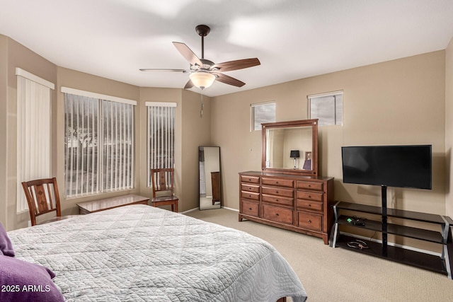 carpeted bedroom with ceiling fan and baseboards