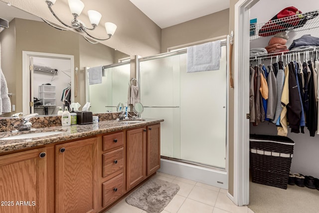 bathroom featuring a stall shower, a sink, and tile patterned floors