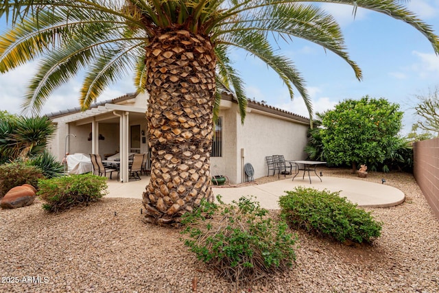 back of house with a patio area, a tiled roof, fence, and stucco siding