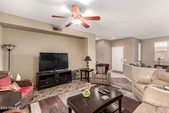 living room featuring ceiling fan, visible vents, and baseboards