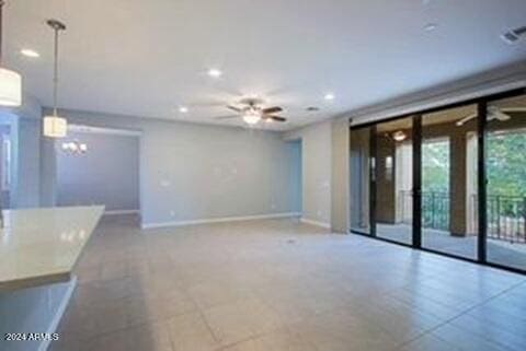 unfurnished living room with ceiling fan with notable chandelier