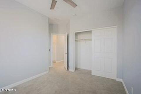 unfurnished bedroom featuring ceiling fan and a closet