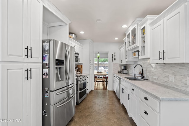 710 E Hayward Ave, Phoenix, AZ 85020 - kitchen featuring appliances with stainless steel finishes, a sink, white cabinetry, tasteful backsplash, and glass insert cabinets